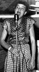 Priscilla Bowman singing with microphone.