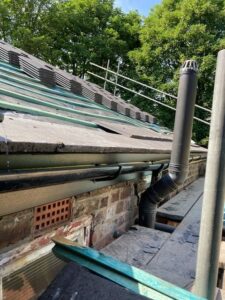 Roof striped of old tiles with new tiles awaiting laying.