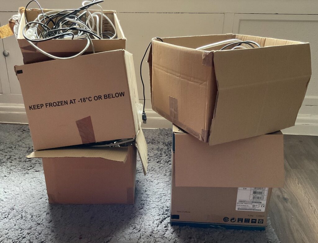 Four cardboard boxes storing redundant cables